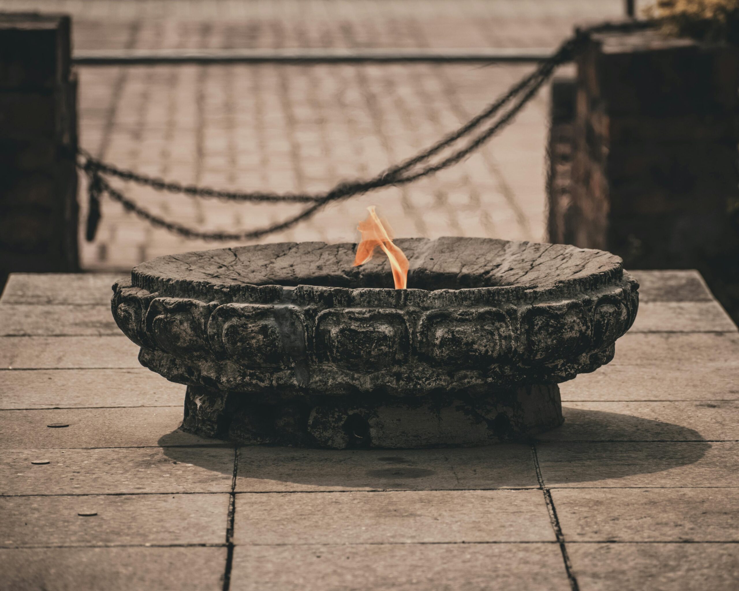 A sacred flame burns on a stone burner in Lumbini, capturing spiritual essence.